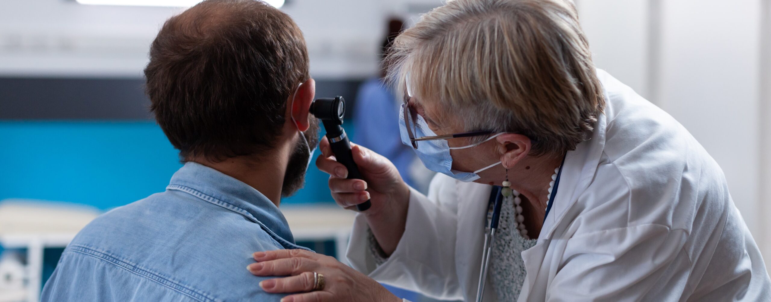 Close up of physician using otoscope to do ear consultation with patient